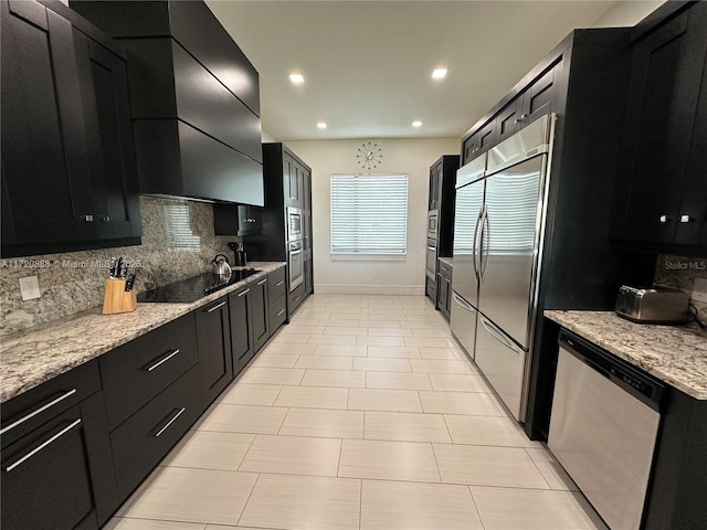 kitchen with premium range hood, stainless steel appliances, light stone countertops, and backsplash