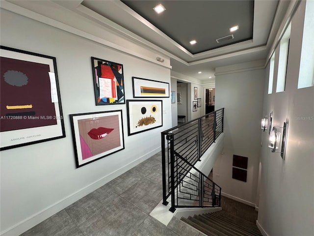 stairway featuring a tray ceiling