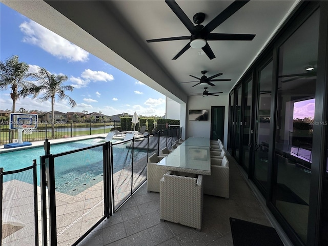 balcony featuring a water view, ceiling fan, and a patio area