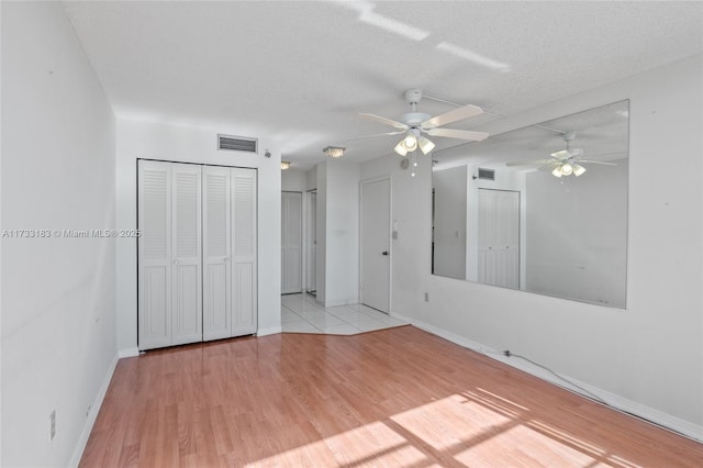 empty room with light hardwood / wood-style floors and a textured ceiling