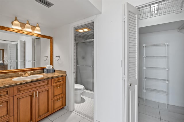 bathroom featuring walk in shower, tile patterned floors, toilet, and vanity