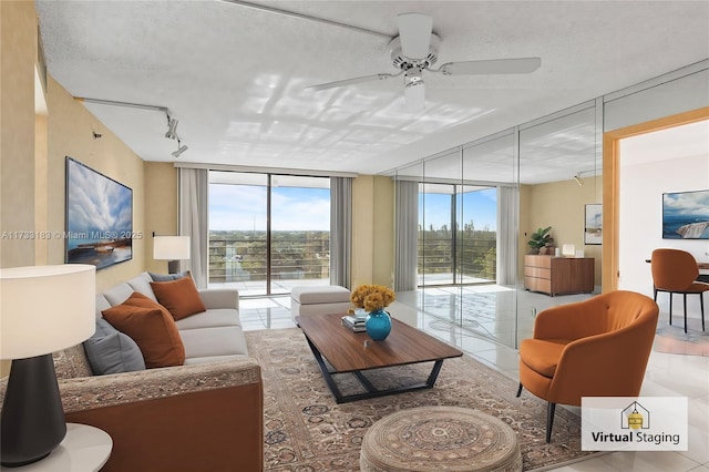 tiled living room featuring ceiling fan, rail lighting, floor to ceiling windows, and a textured ceiling