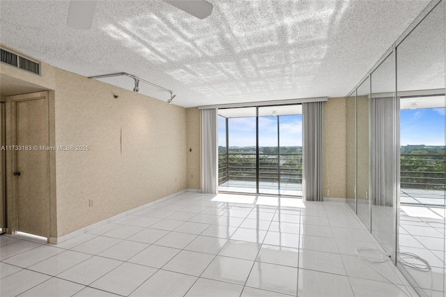 1200 Saint Charles Pl Unit Ph7, Pembroke Pines, FL 33026 - empty room featuring a wall of windows, light tile patterned floors, a ceiling fan, and a textured ceiling