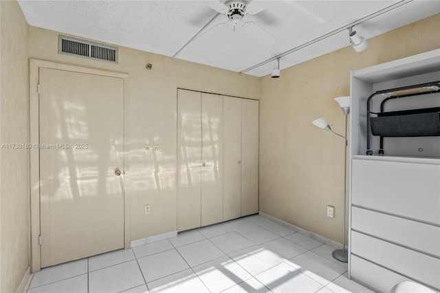 1200 Saint Charles Pl Unit Ph7, Pembroke Pines, FL 33026 - unfurnished bedroom featuring a closet, light tile patterned floors, baseboards, a textured ceiling, and a ceiling fan