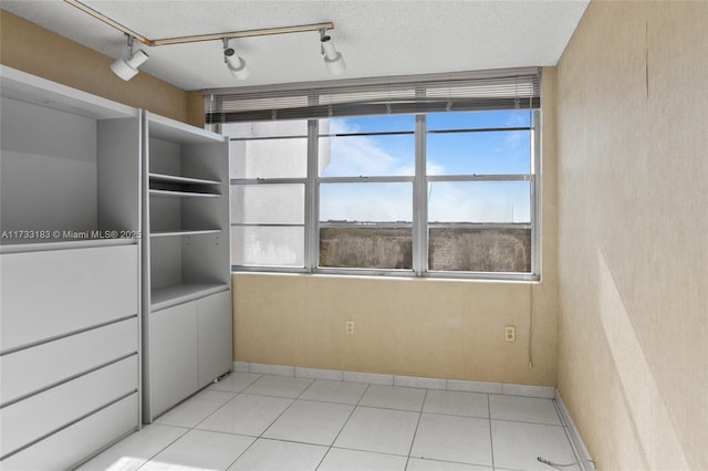 tiled spare room featuring a textured ceiling