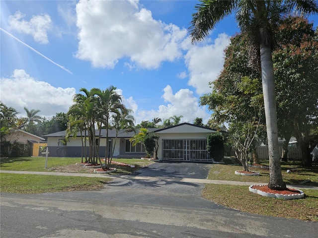 single story home featuring a garage and a front lawn