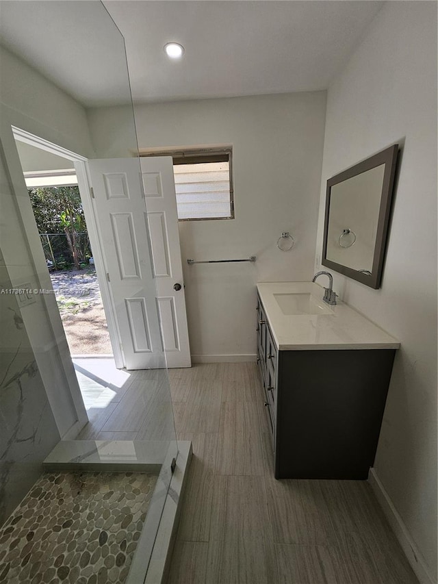 bathroom featuring walk in shower, vanity, and hardwood / wood-style flooring