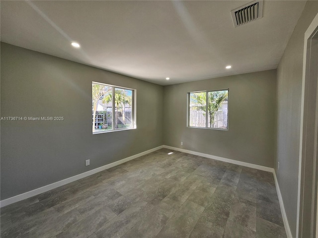 empty room with dark hardwood / wood-style floors and a healthy amount of sunlight