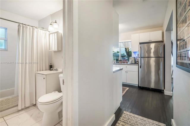 full bathroom featuring a healthy amount of sunlight, toilet, shower / tub combo, and vanity