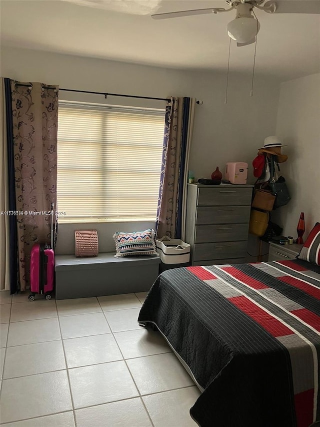 bedroom featuring ceiling fan, multiple windows, and light tile patterned floors