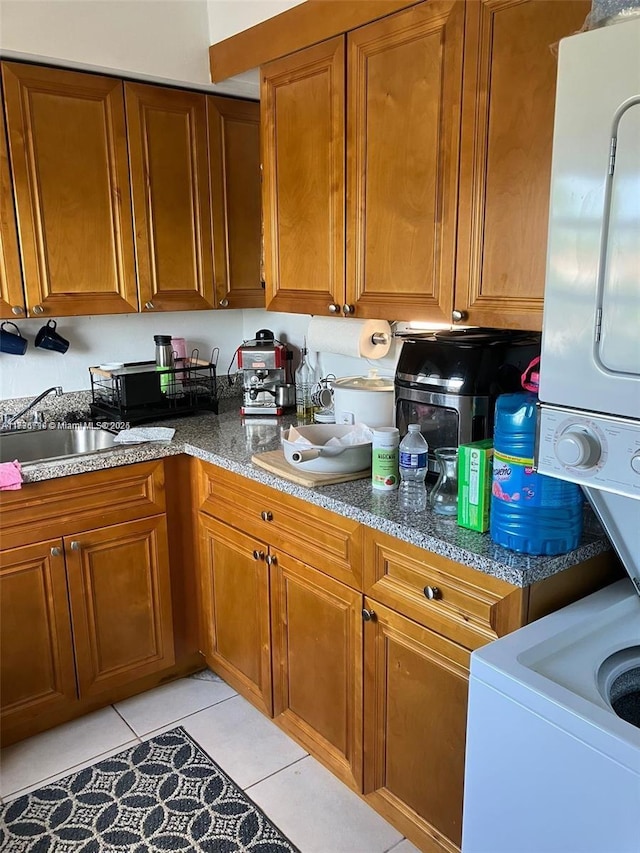 kitchen featuring stone countertops, sink, and light tile patterned floors