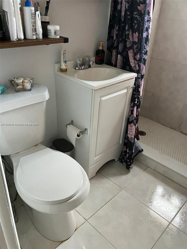 bathroom featuring vanity, curtained shower, tile patterned floors, and toilet