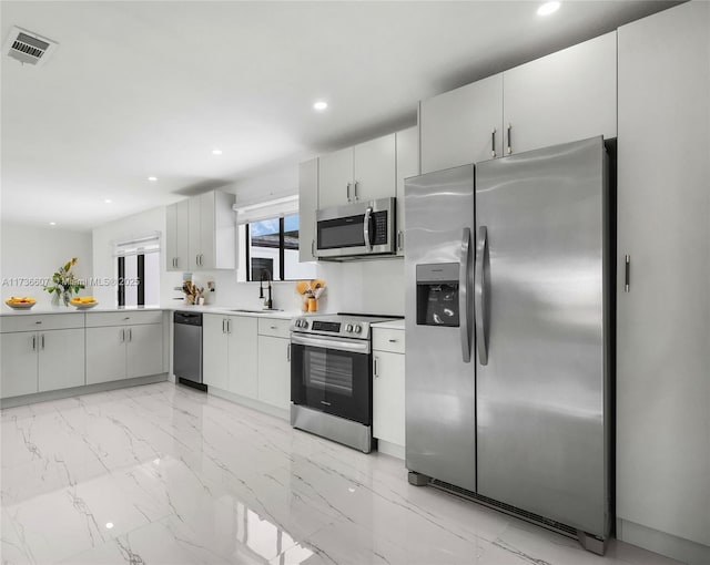 kitchen with white cabinetry, stainless steel appliances, and sink