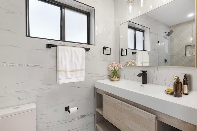 bathroom with vanity, toilet, tile walls, and a shower