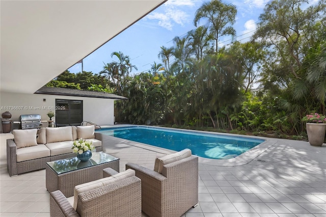 view of pool with an outdoor living space, a patio area, and a grill