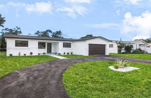 ranch-style house featuring a garage and a front yard