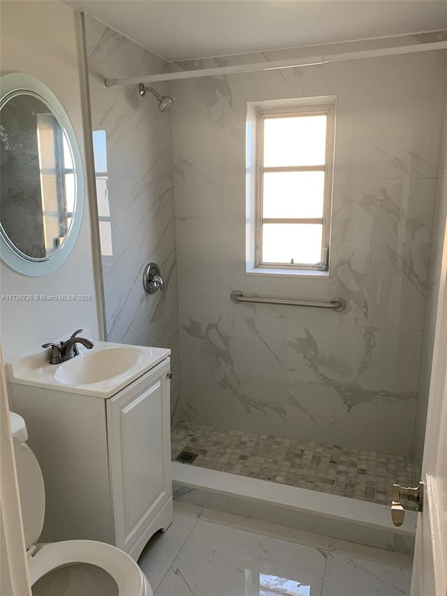 bathroom featuring vanity, toilet, and tiled shower