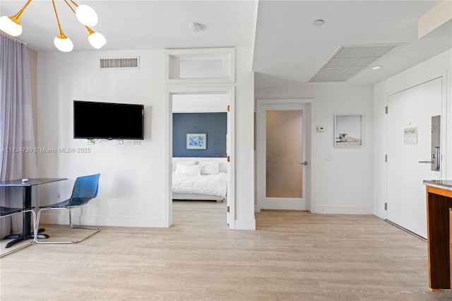 interior space featuring an inviting chandelier and light wood-type flooring