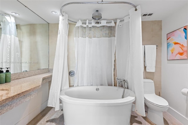 bathroom featuring vanity, a tub, and toilet