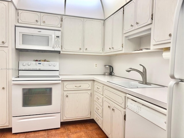 kitchen with white appliances, tile patterned flooring, and sink