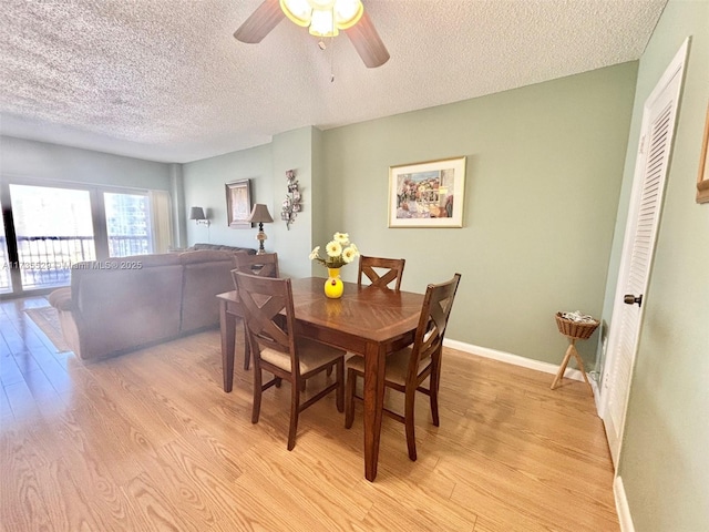 dining room with ceiling fan, a textured ceiling, and light wood-type flooring