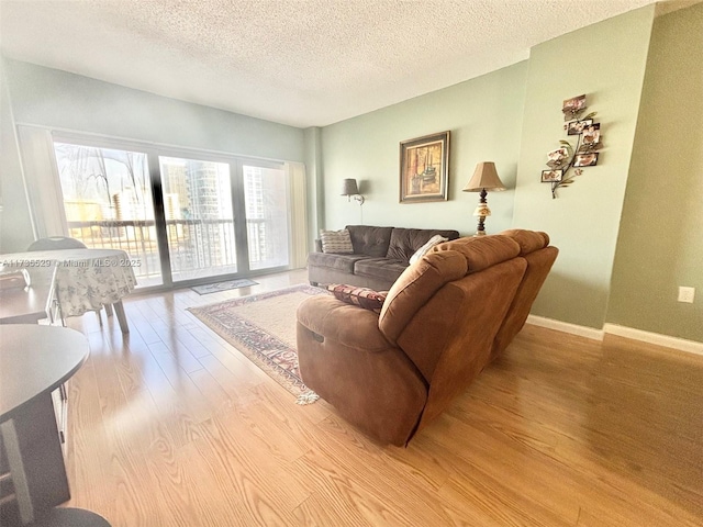 living room with a textured ceiling and light wood-type flooring