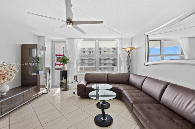 tiled living room with ceiling fan and a textured ceiling