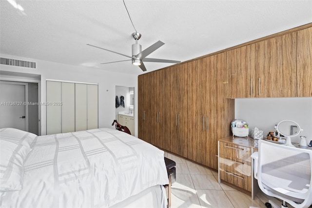 tiled bedroom featuring multiple closets, ceiling fan, and a textured ceiling