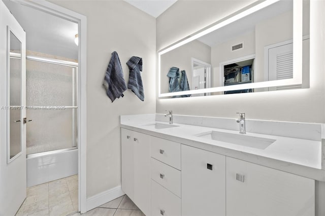 bathroom featuring vanity, tile patterned flooring, and enclosed tub / shower combo