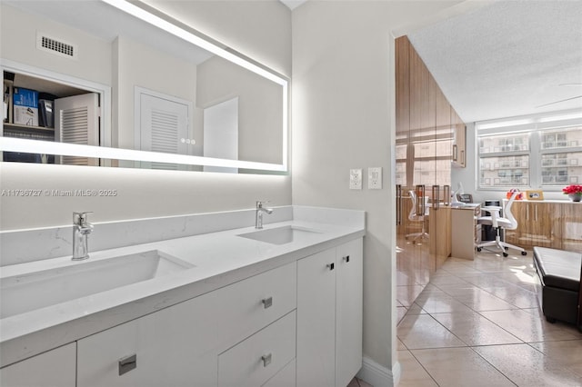 bathroom featuring vanity, tile patterned floors, and a textured ceiling