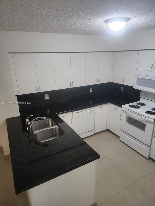 kitchen with white cabinetry, sink, light tile patterned floors, white appliances, and a textured ceiling