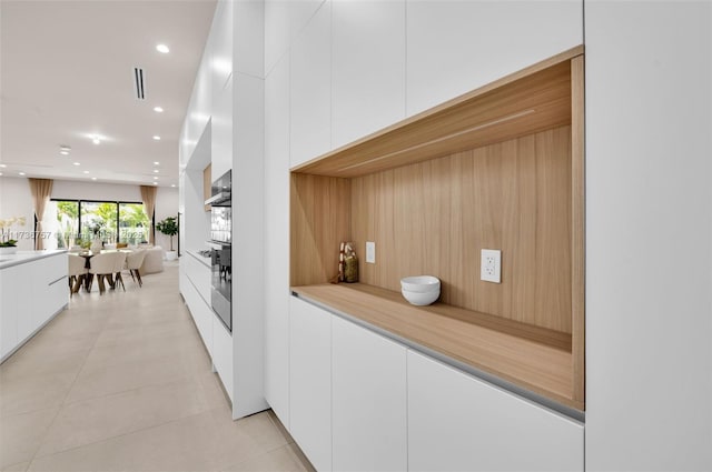 interior space featuring white cabinetry and light tile patterned flooring