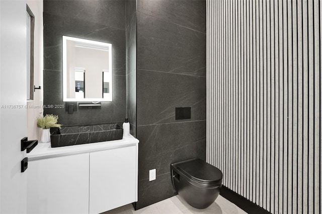 bathroom with tile walls, vanity, and toilet