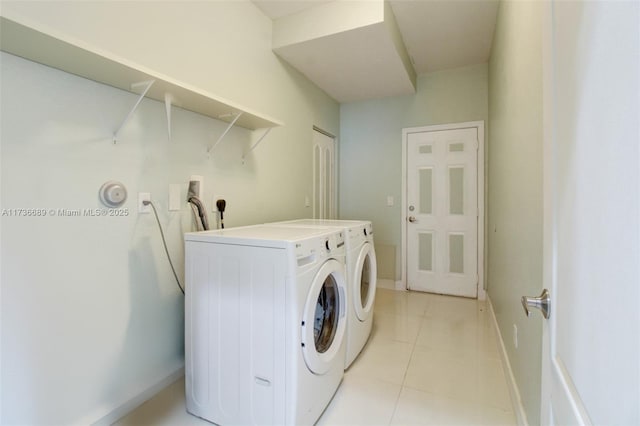 laundry room featuring washing machine and dryer and light tile patterned floors