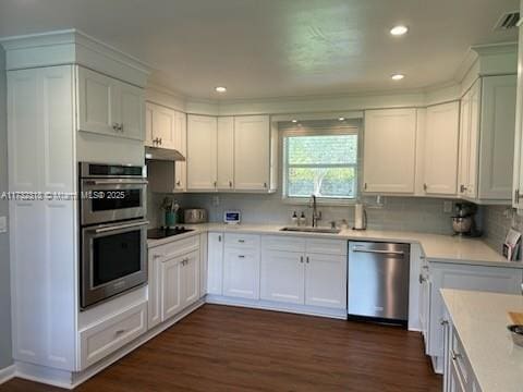 kitchen with white cabinetry, appliances with stainless steel finishes, dark hardwood / wood-style floors, and sink