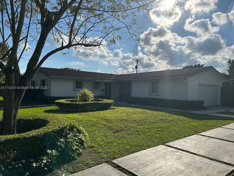 single story home featuring a garage and a front yard