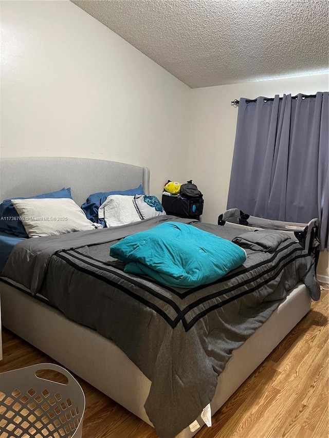 bedroom featuring hardwood / wood-style flooring and a textured ceiling