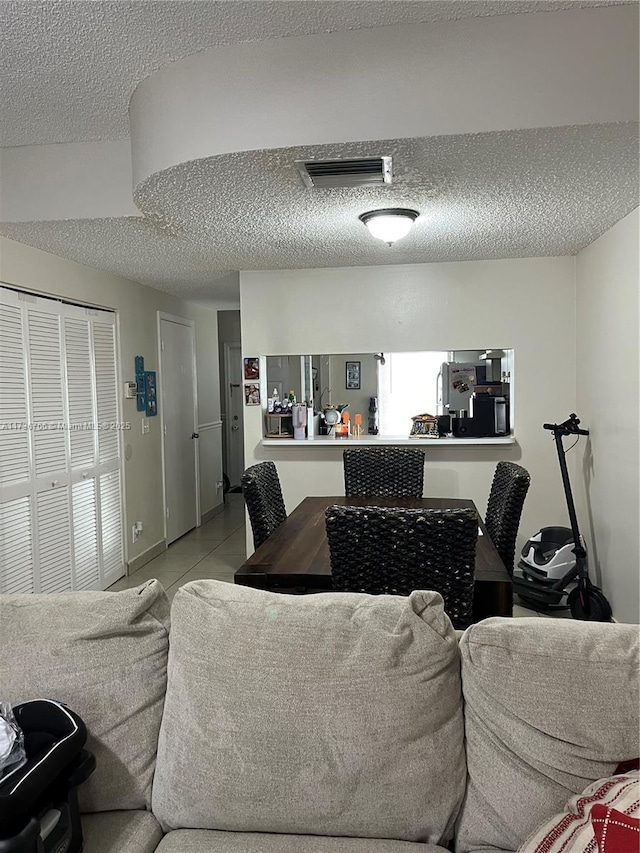 tiled living room featuring a textured ceiling