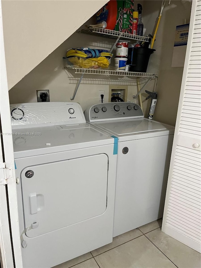 laundry area featuring light tile patterned floors and washer and dryer