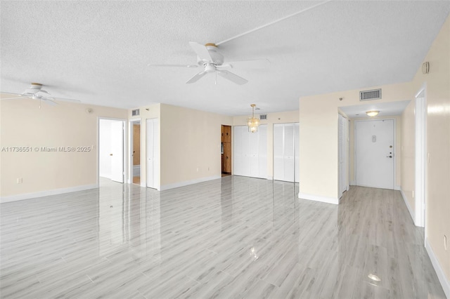 unfurnished room featuring ceiling fan, light hardwood / wood-style floors, and a textured ceiling