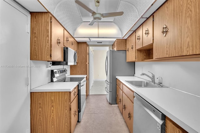 kitchen featuring appliances with stainless steel finishes, sink, light tile patterned floors, and ceiling fan