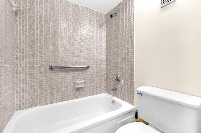 bathroom with tiled shower / bath and toilet