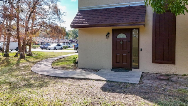 view of exterior entry featuring a yard