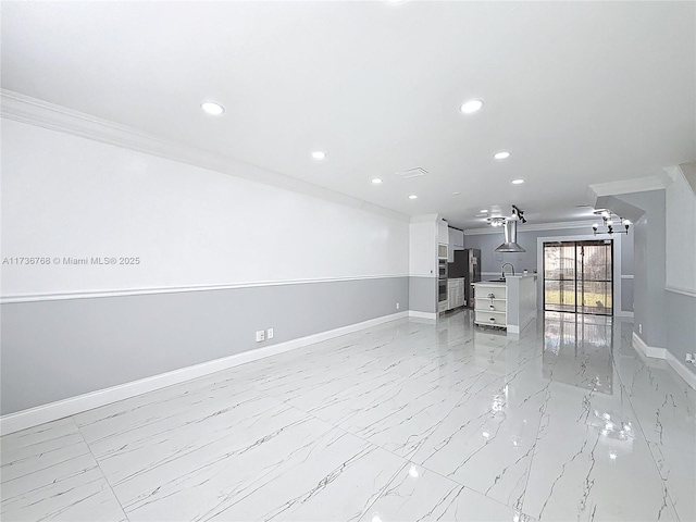 unfurnished living room with sink and ornamental molding