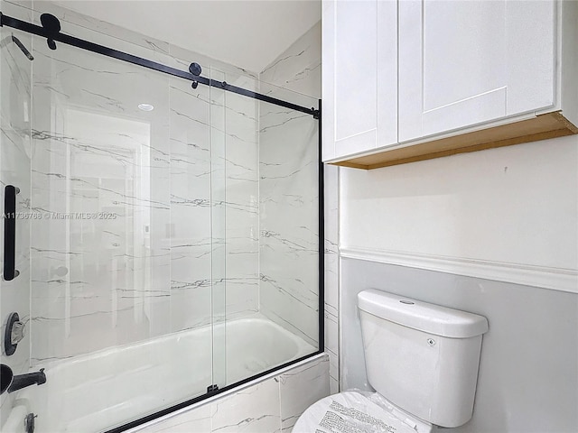 bathroom with shower / bath combination with glass door and toilet