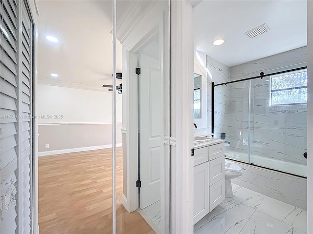 full bathroom featuring toilet, bath / shower combo with glass door, ornamental molding, vanity, and hardwood / wood-style floors