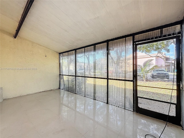 tiled empty room featuring floor to ceiling windows