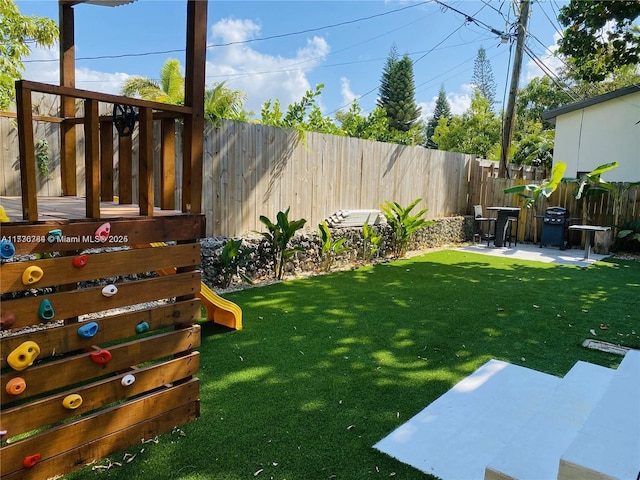 view of yard featuring a playground and a patio area