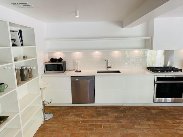 kitchen featuring white cabinetry, stainless steel appliances, sink, and tasteful backsplash