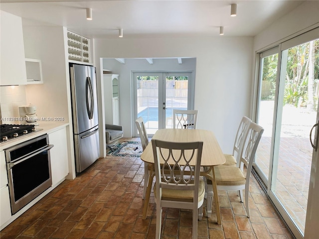 kitchen featuring french doors, white cabinetry, appliances with stainless steel finishes, and plenty of natural light